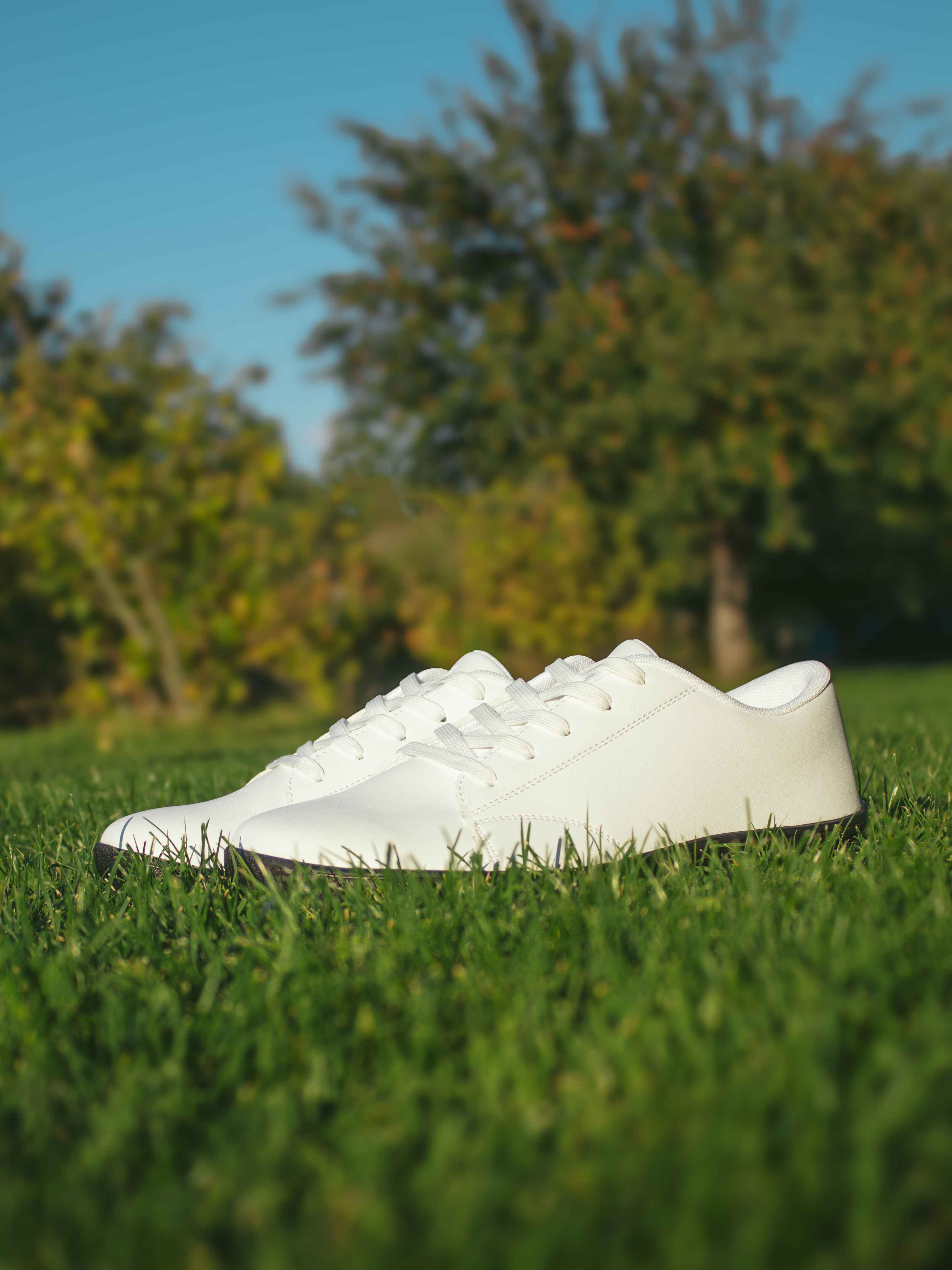 Białe buty barefoot Mitochondriak na trawie podczas groundingu