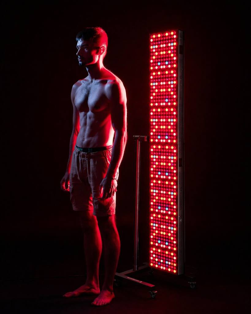 Muž pri terapii červeným svetlom infrapanelom, stimulácia mitochondrií a cytochróm c oxidázy